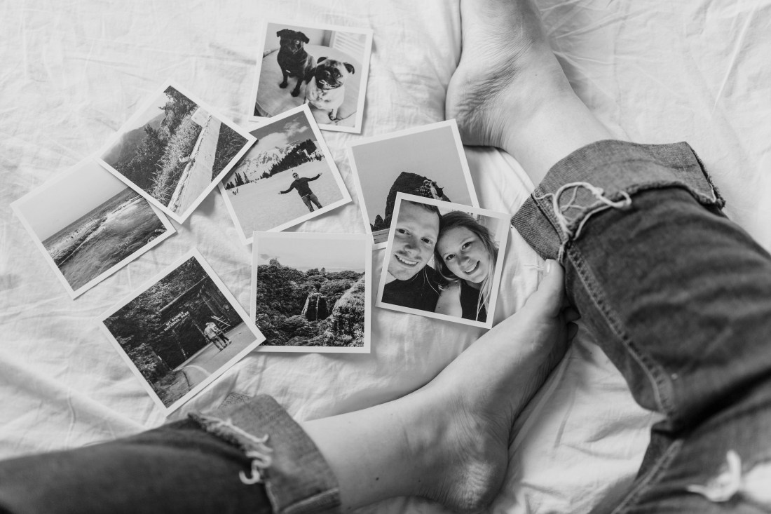 Photographs of past memories displayed on a woman's bed.