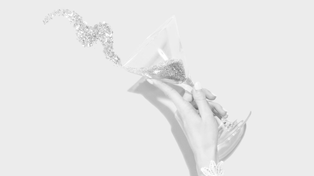 Woman tossing glitter from a martini glass